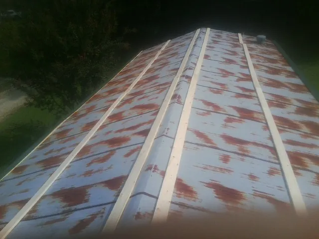 Rusted metal roof panels with new wood purlins before replacement — Storm Damage Roof Repair in Udall by Roofing Brothers